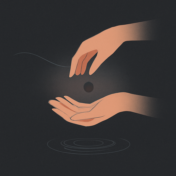 In soft dawn light, open hands release a small stone into calm water